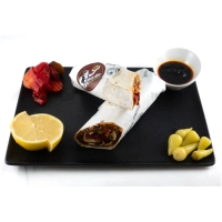 Çiğköfte, lavas brood, groenten, granaatappelsaus en pittige Hanzade saus. Ijsbergsla, rucola, tomaten, komkommer, citroen, rode kool, mais